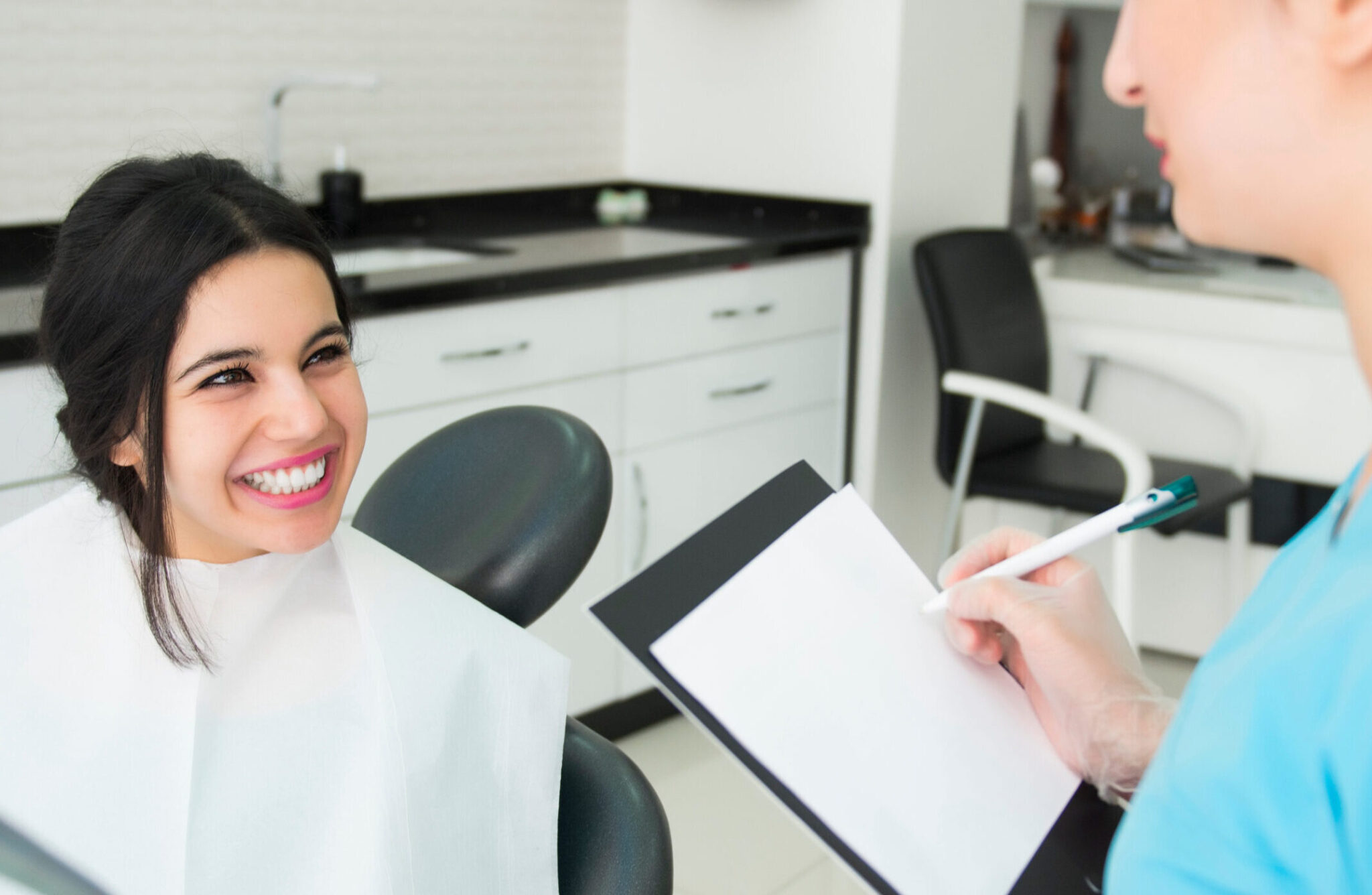 Woman Smiles As She Checks In With Her Orthodontist