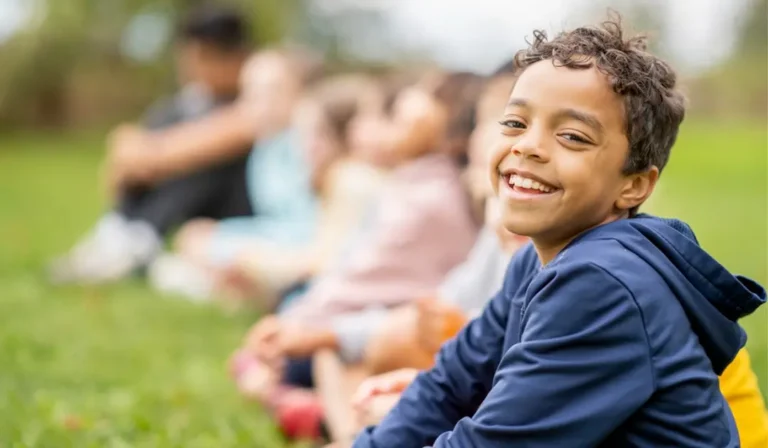 Happy Boy In A Field With Other Kids