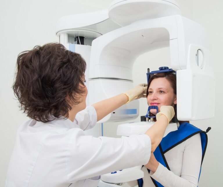 A young dentist taking a panoramic digital X-ray of a patient s teeth