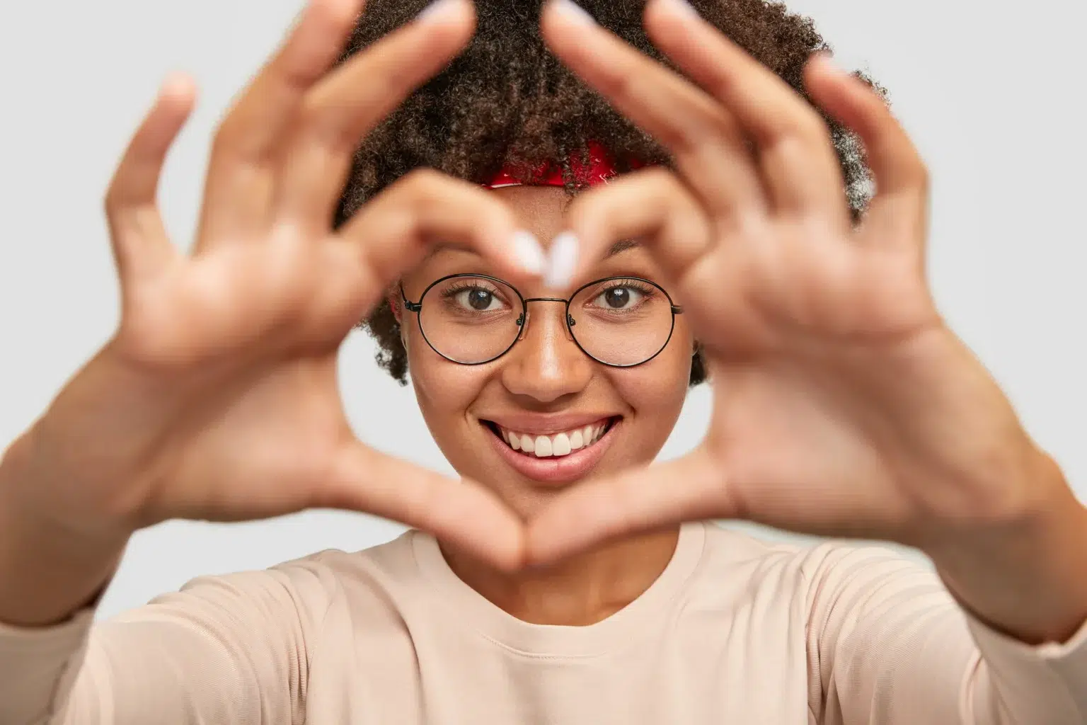 Close Up Shot Cheerful Carefree Charming Dark Skinned Girl Makes Heart Shape Hand Sign Face
