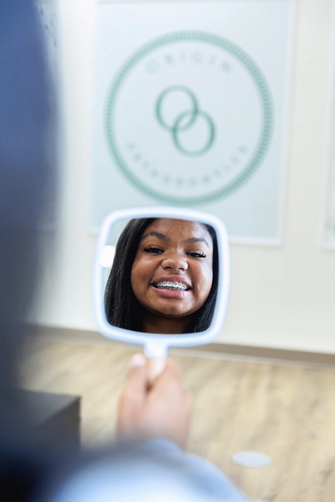 Patient With Braces Smiling In Mirror