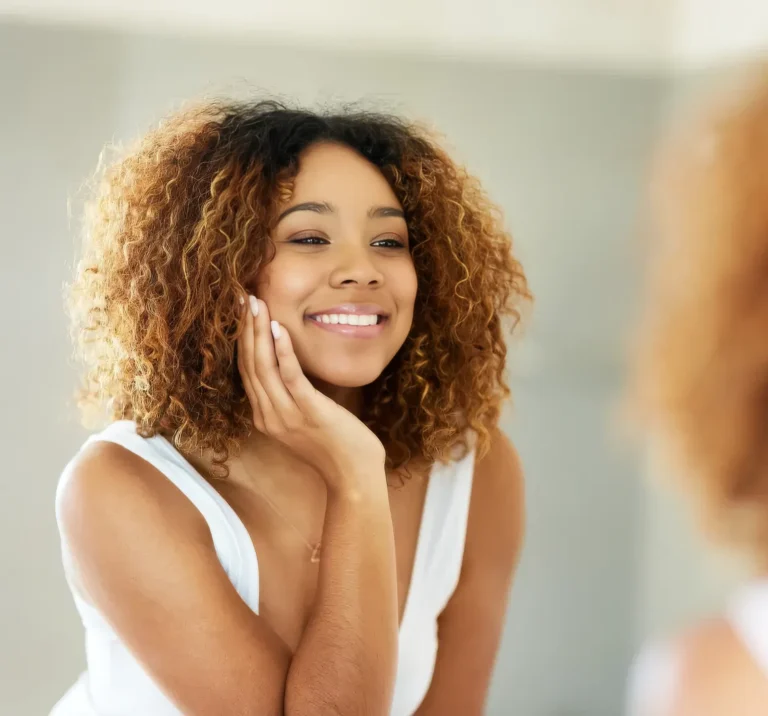 A Beautiful Woman Admiring Her Smile In A Mirror